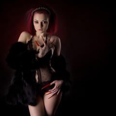 Beautiful sexy woman with red hair and long nails in fur coat