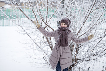 Portrait of a happy little girl on the background of a winter pa