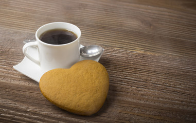 Heart shaped cookie with a cup of coffee