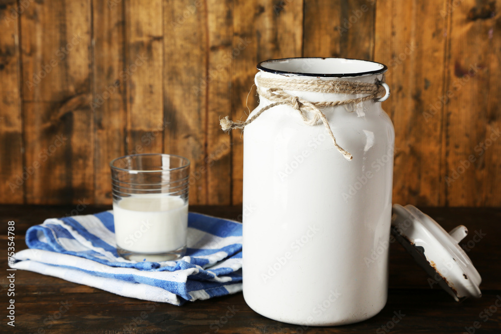 Open milk can on dishcloth on rustic wooden background