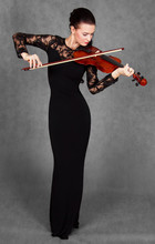 Portrait Of A Young Attractive Violinist Woman In A Black Evenin