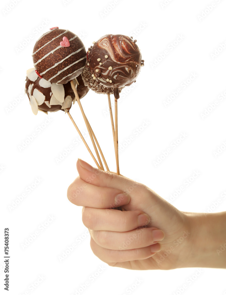 Female hand holding cake pops, isolated on white