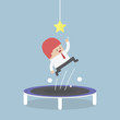 Businessman trying to catch the star by jumping on trampoline