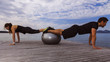 © imacture - Man and woman doing push-ups with exercice ball