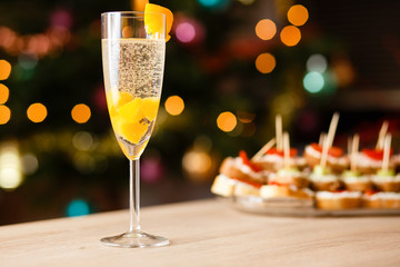 A glass of sparkling wine with apricot on the table