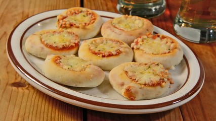 Poster - Plate of mini pizzas being served on a bar counter