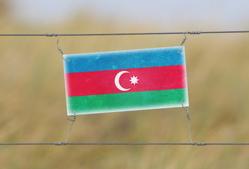 Wall Mural - Border fence - Old plastic sign with a flag