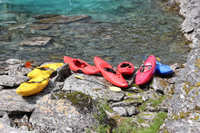 Seven Kayaks On The River Bank.