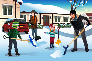 Wall Mural - Family shoveling snow in front of their house