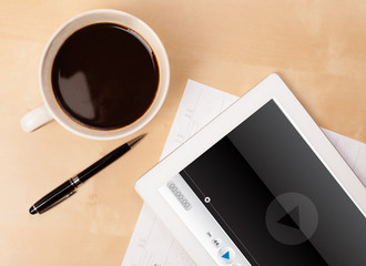 Wall Mural - tablet pc showing media player on screen with a cup of coffee on