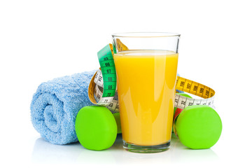 Two green dumbells, tape measure and orange juice. Fitness and h