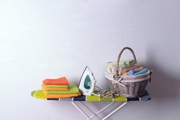 Wall Mural - Ironing board with laundry on light background