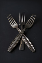 Conceptual Still Life Of Three Vintage Silver Forks