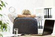 © Oksana Kuzmina - Woman relaxing in office sitting back in chair with hands behind