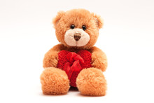 Isolated Teddy Bear Holding A Heart With A Ribbon.