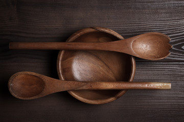 empty salad bowl and two spoons on wooden table