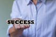© fosupaksorn - businessman is holding a word SUCCESS