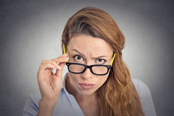 Angry bitchy woman with glasses skeptically looking at you