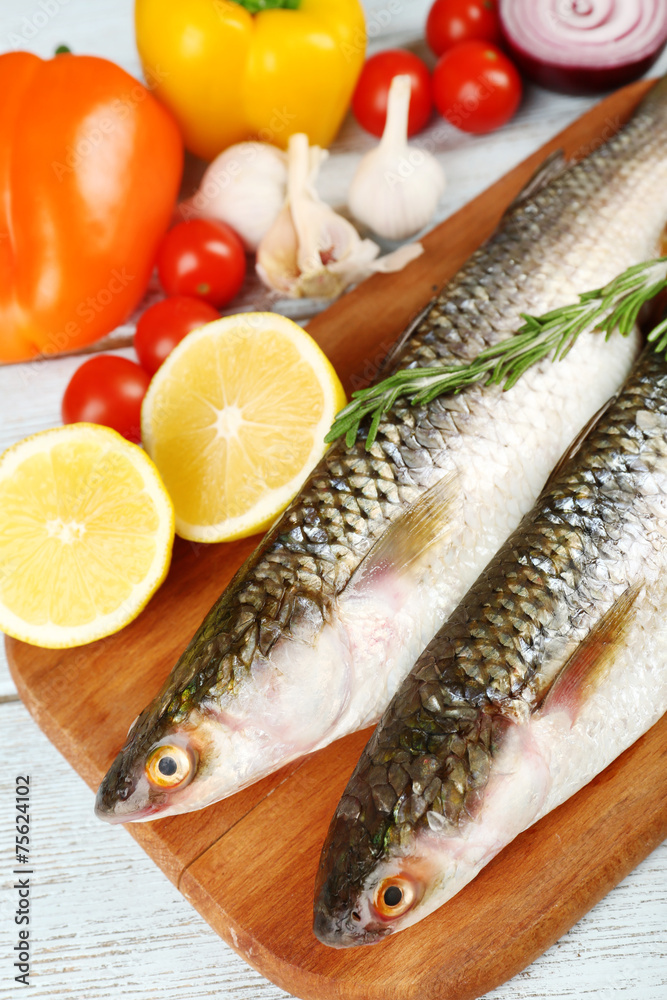 Fresh raw fish and food ingredients on table