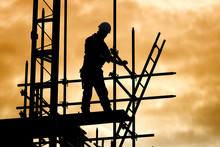 Silhouette Construction Worker On Scaffolding Building Site
