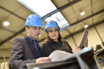 Architects in industrial workshop checking on project