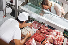 Butcher Showing Meat To Customer At Butchery