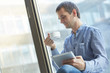 © photoniko - businessman with a cup of coffee and with the tablet at the wind