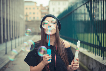 young beautiful brunette woman girl blowing bubbles soup