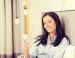 © Syda Productions - happy businesswoman with smartphone in hotel room