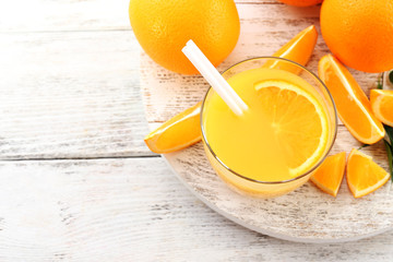 Glass of orange juice with straw and slices