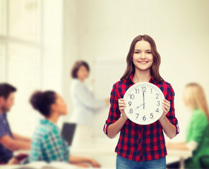 Canvas Print - young woman in casual clothes with wall clock