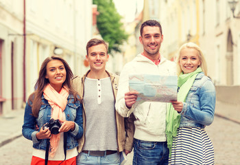 Canvas Print - group of smiling friends with map and photocamera