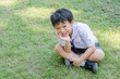 © gamelover - Happy Asian student sitting on grass field