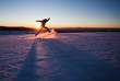 silhouetted man running through snow in winter landscape