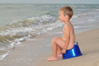 Boy sitting on a potty on the seashore