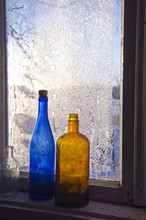 Two Old Bottle On Frosty Farm Winter Window