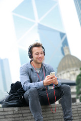 Wall Mural - Urban man on smart phone wearing headphones