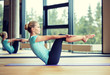 © Syda Productions - smiling woman doing exercises on mat in gym