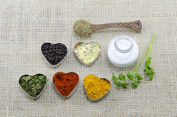 Wall Mural - Various spices in heart chaped containers with salt and spoon