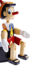 Pinocchio Toy Sitting On White. 