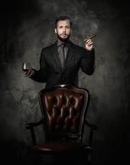 Wall Mural - Handsome well-dressed with glass of beverage and cigar