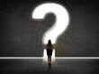 © ra2 studio - Business woman looking at wall with a bright question mark