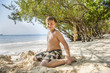 © travelview - happy young boy is digging in the sand of the beach