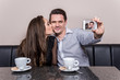 Loving couple taking selfie at cafe