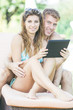 © william87 - Young Couple on Vacation using Digital Tablet