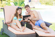 © william87 - Young Couple on Vacation using Digital Tablet