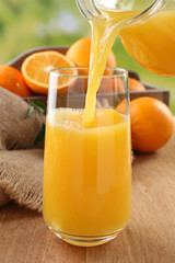 Wall Mural - Pouring orange juice from glass carafe,