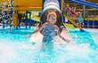 © travnikovstudio - Little girl on water slide at aquapark during summer holiday