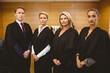 © WavebreakMediaMicro - Four serious judges standing while wearing robes