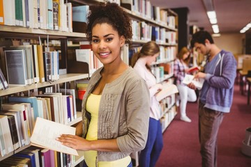 Poster - Happy student taking book from shelf